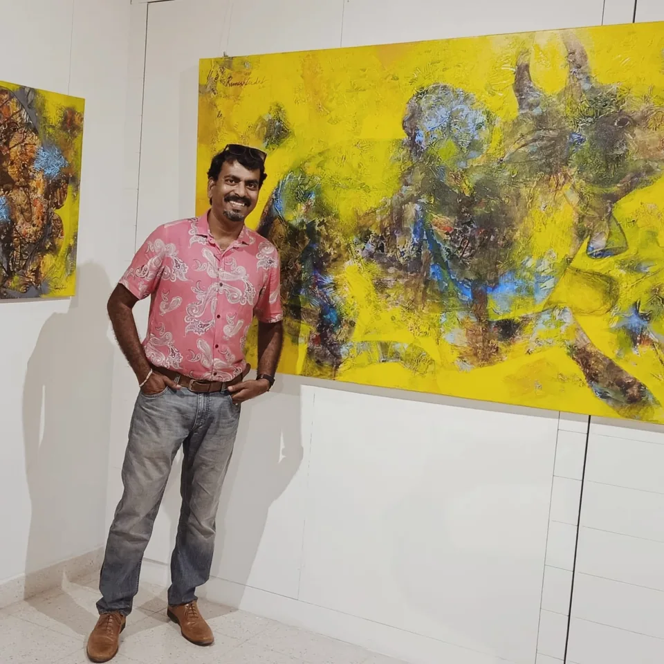 Ramesh Terdal standing beside his large yellow abstract painting