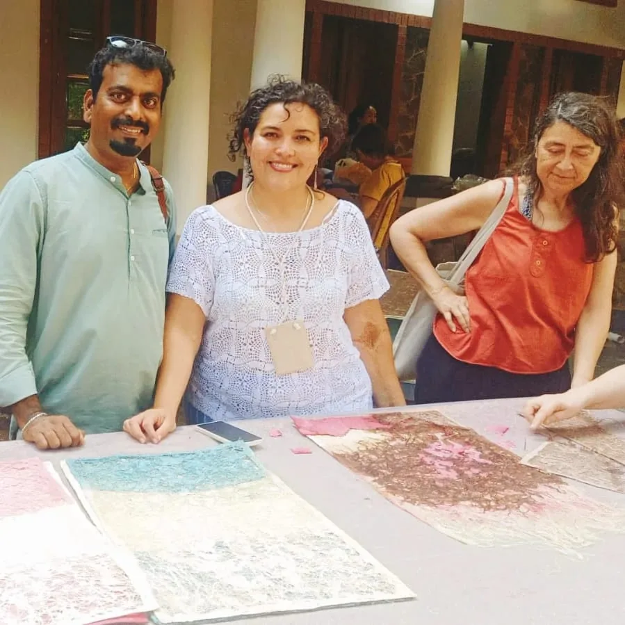 Ramesh Terdal with two fellow artists at a table of textured handmade paper works