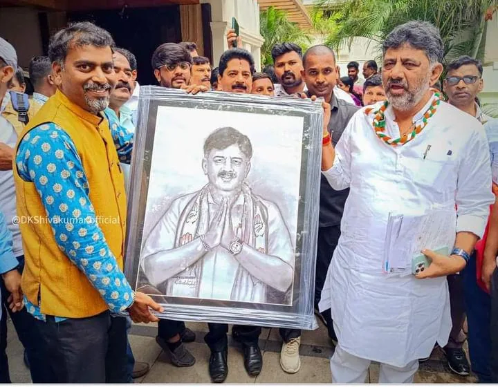 Ramesh Terdal presenting a framed charcoal portrait to DK Shivakumar in Bangalore